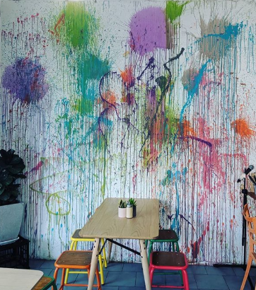 Creativity is alive and well at this Port Kembla cafe that splatters art down the walls in a waterfall pattern