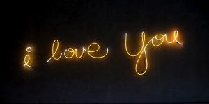 celebrating the ideal freelance client with neon lights that read i love you on a black background
