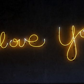 celebrating the ideal freelance client with neon lights that read i love you on a black background