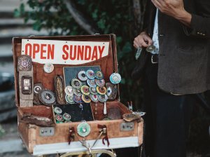 A suitcase full of equipment has a sign that reads open sunday. You need more than this to ace your web content marketing