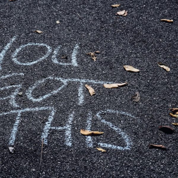 a bitumen road has 'you got this' scrawled on it in chalk. Used to demonstrate the power of confidence in coaching and mentoring.
