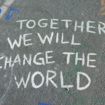 a bit of chalk is written on the sidewalk- it reads 'together we will change the world' - which is a common sentiment during this time of cultural transformation