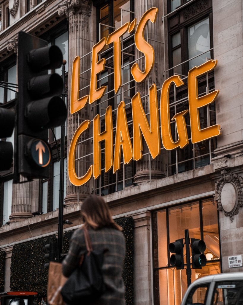 a neon building sign reads let's change to inspire Australian changemakers