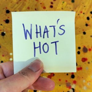 a post-it note with what's hot written on it in front of a painting signifies australian marketing trends